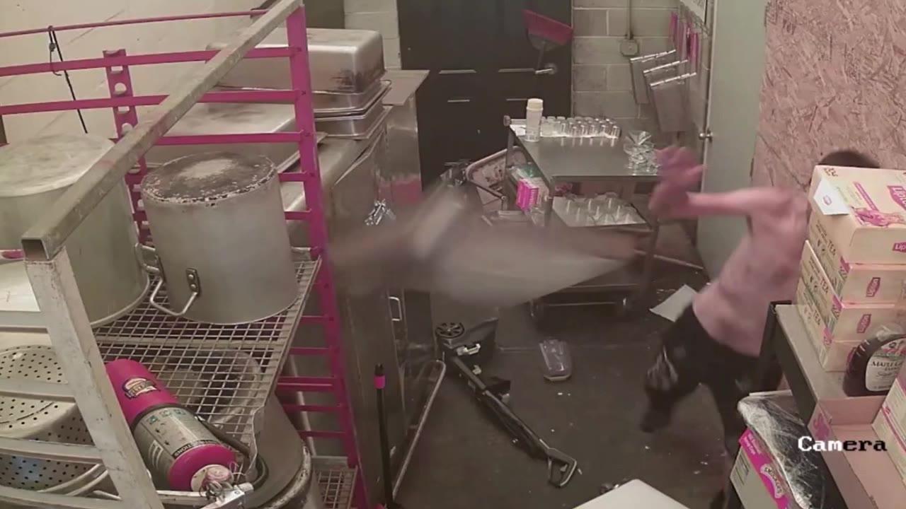 El hombre sin camisa arroja una sartén de metal a la cámara de seguridad durante el robo destructivo del negocio de catering de Philly